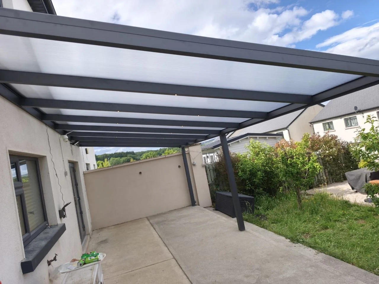 Long view of the transparent polycarbonate pergola covering the rear patio in Rathdrum