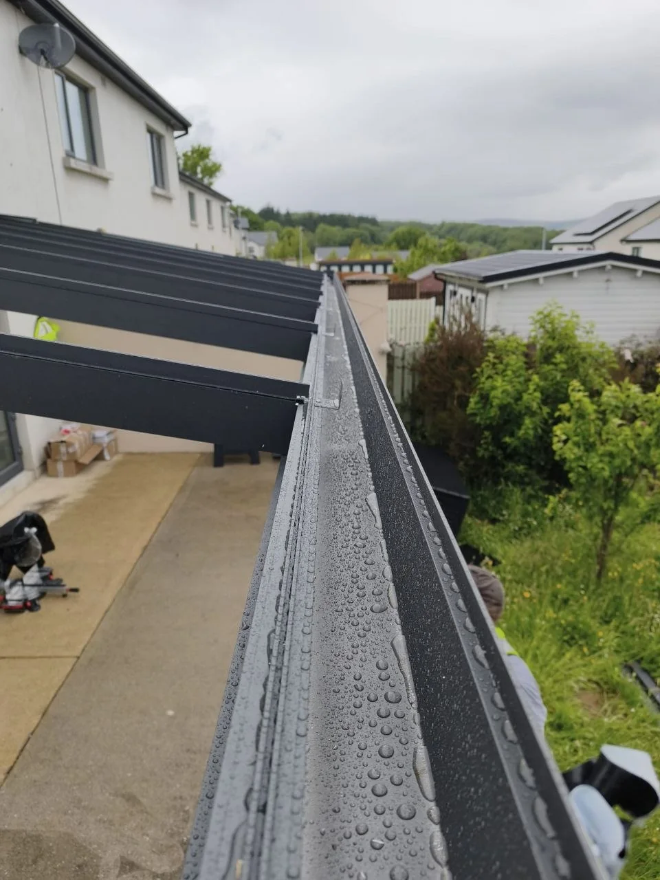 Integrated rainwater drainage detail on the wall-mounted pergola in Rathdrum