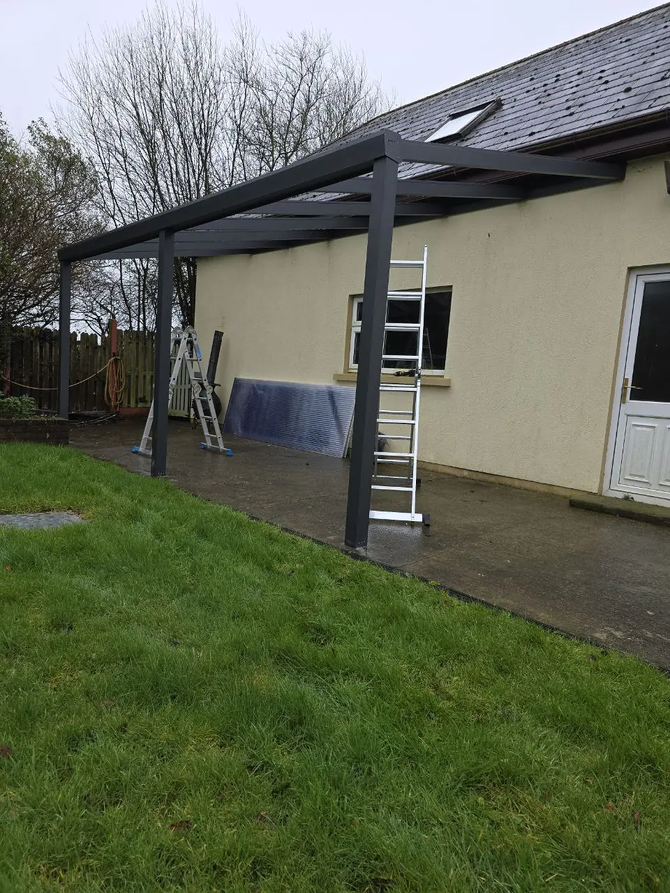 Angled view of the wall-mounted pergola frame before fitting the roof sheets