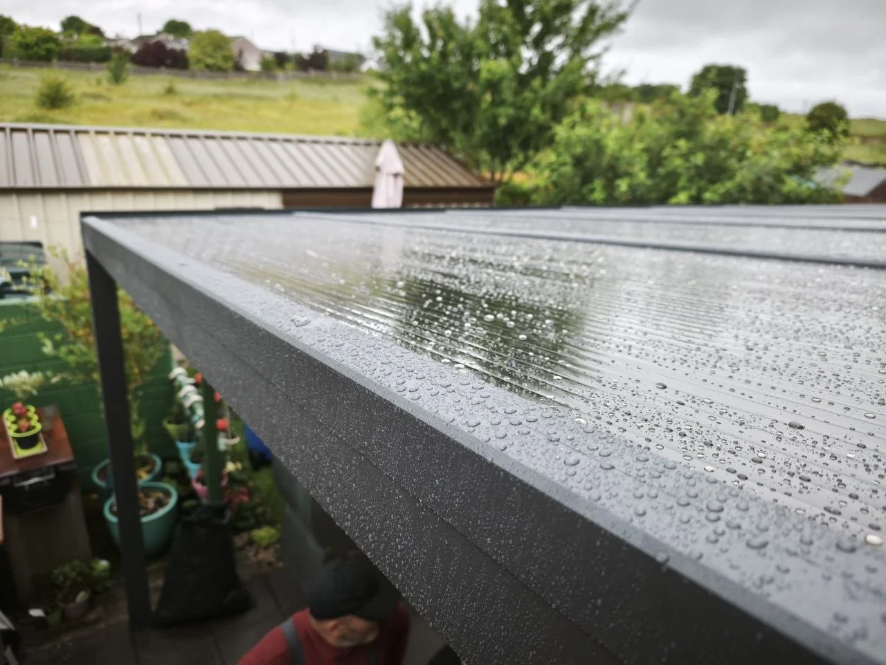 Polycarbonate pergola roof providing rain protection over the patio in Ennis