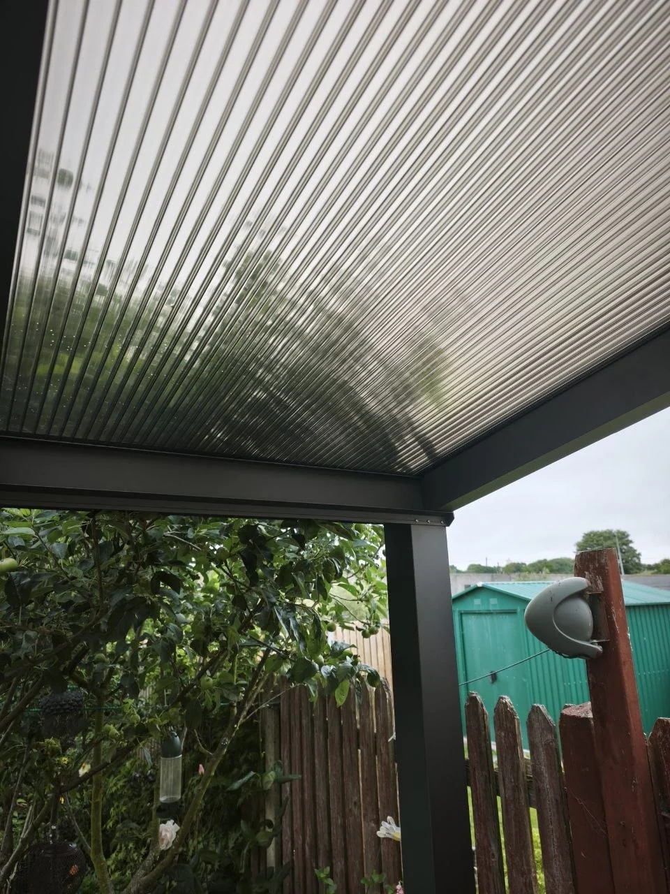 View beneath the completed polycarbonate pergola covering the residential patio in Ennis