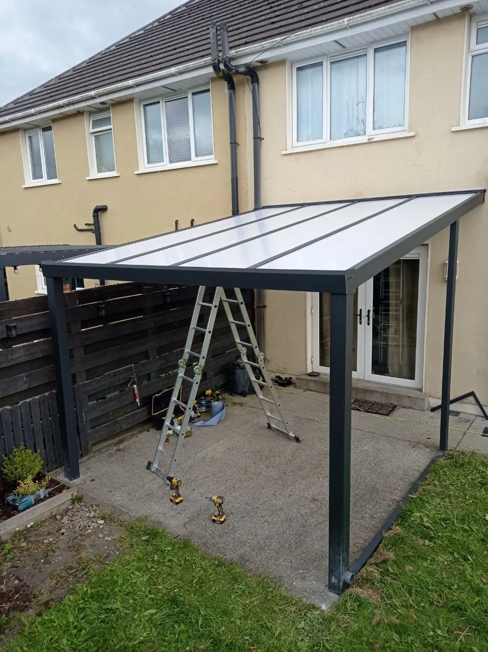 Rear patio in Portlaoise before installation of the wall-mounted aluminium pergola