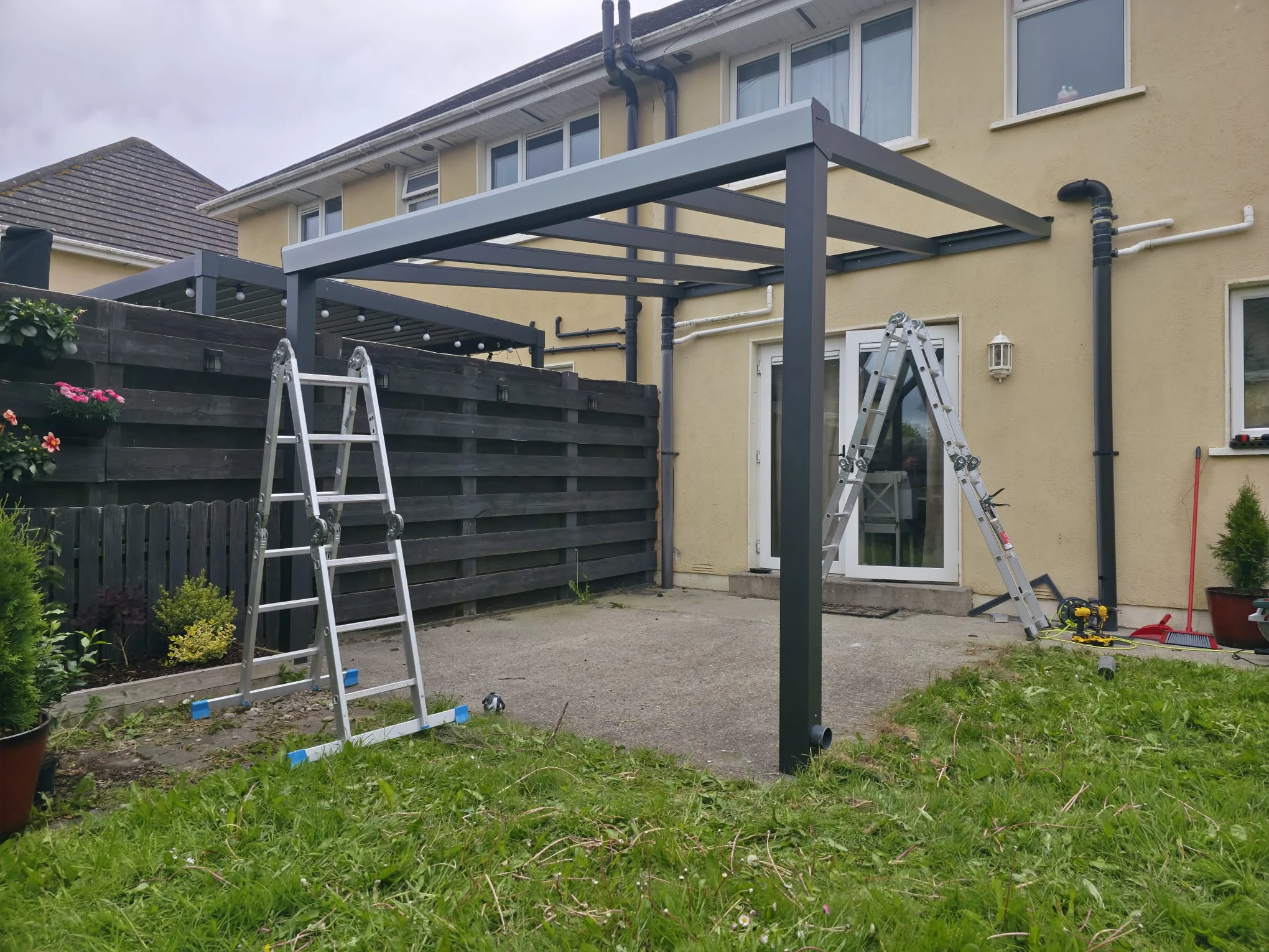 Anthracite aluminium pergola frame during installation beside the home in Portlaoise