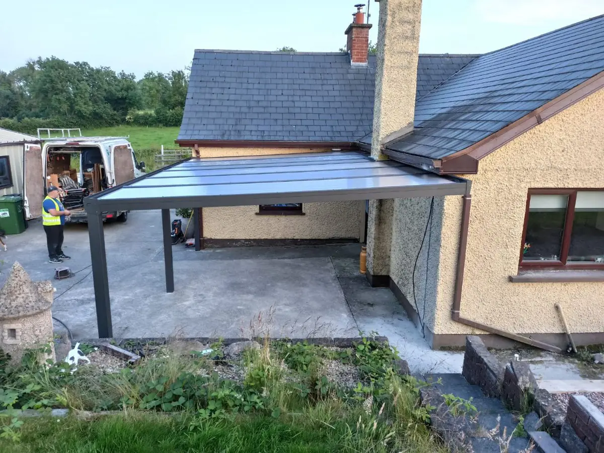 Elevated view of the completed polycarbonate pergola roof fitted around the projecting chimney