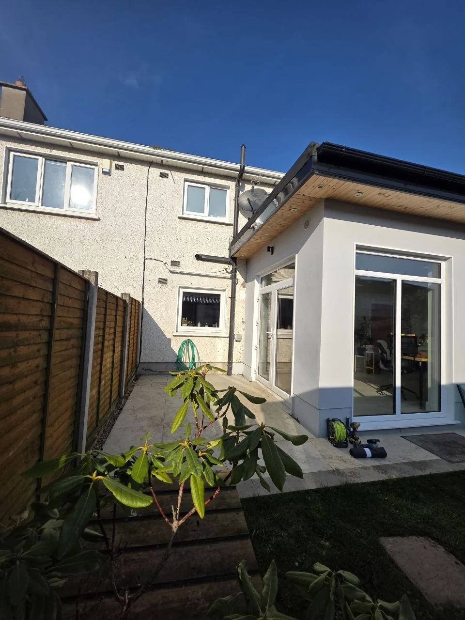 Rear patio beside a Dublin home before installation of the wall-mounted glass canopy