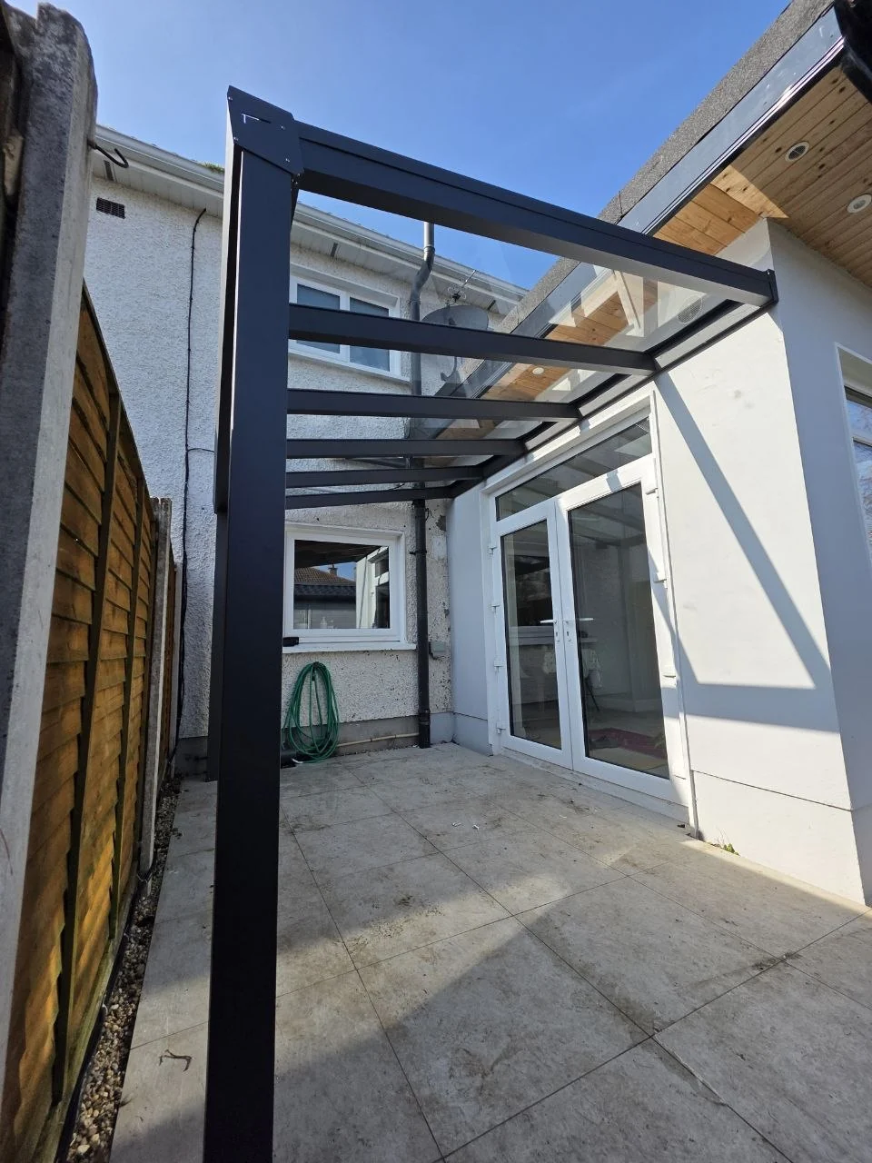 Wall-mounted aluminium canopy structure installed beside the back entrance of a Dublin home