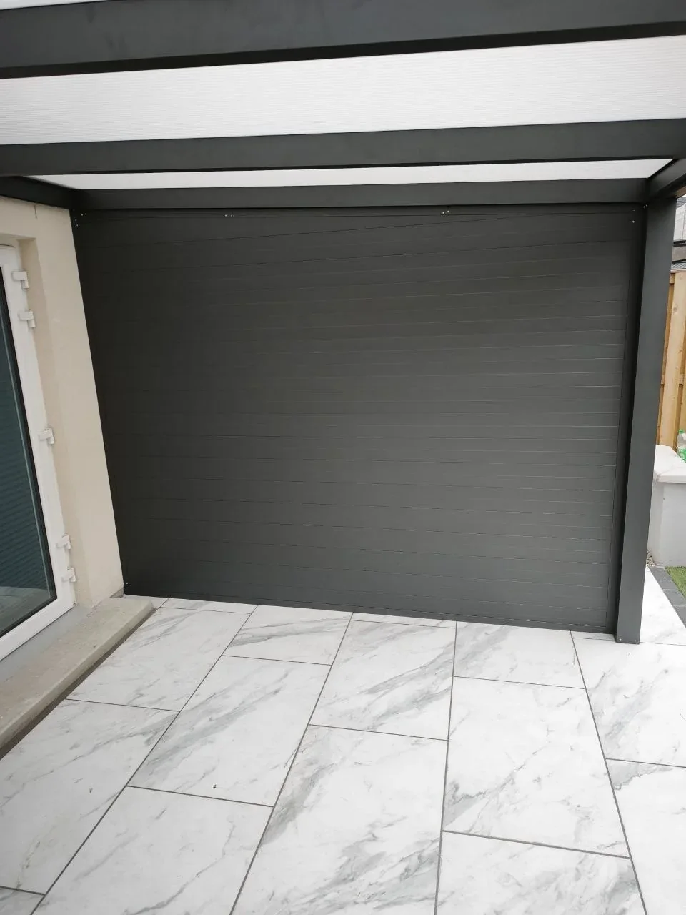 Full-height anthracite tongue-and-groove aluminium side wall on the Cork pergola